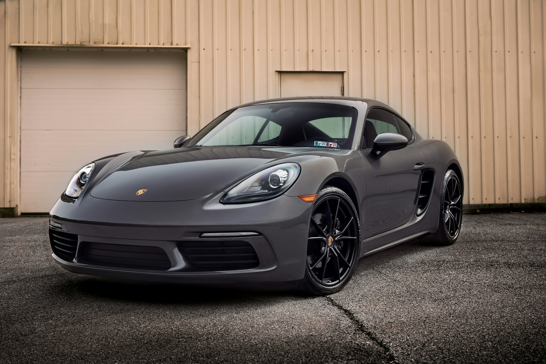 Porsche 718 Cayman 停在工作室外牆前
